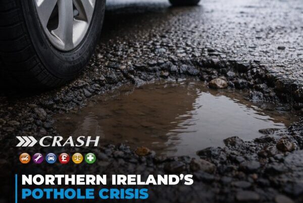 A close-up view of a deep, water-filled pothole on a wet Northern Ireland road.